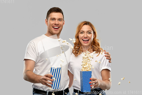 Image of happy couple in white t-shirts eating popcorn