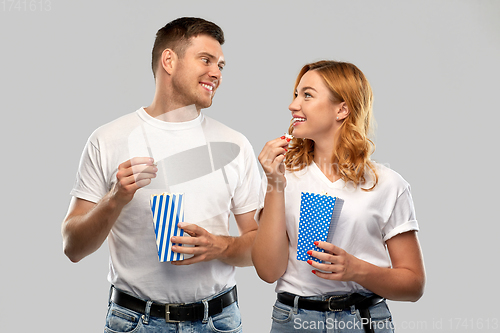 Image of happy couple in white t-shirts eating popcorn