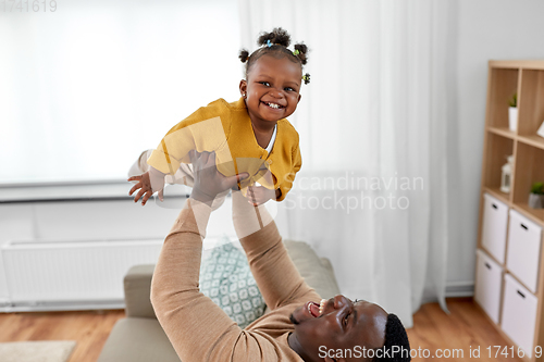 Image of happy african american father with baby at home