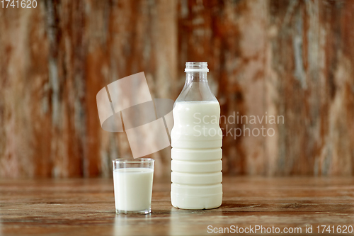 Image of glass and bottle of milk on wooden table