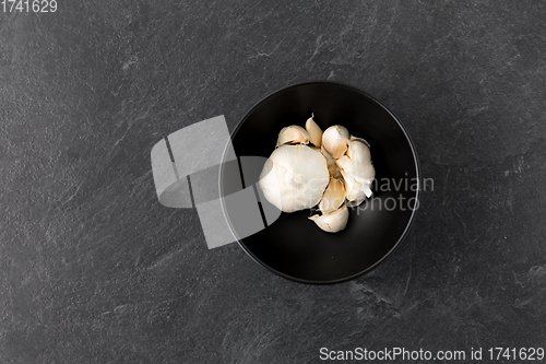 Image of garlic in bowl on slate stone background