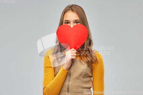 Image of smiling teenage girl hiding over red heart