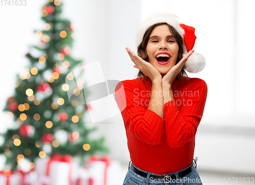 Image of happy young woman in santa hat on christmas