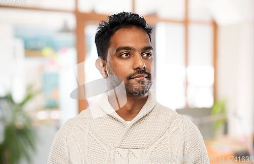 Image of indian man in sweater over office background