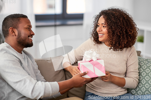Image of happy couple with gift at home