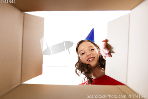 Image of happy young woman looking into open birthday gift