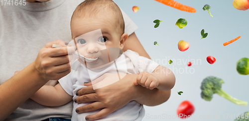 Image of close up of mother with spoon feeding little baby