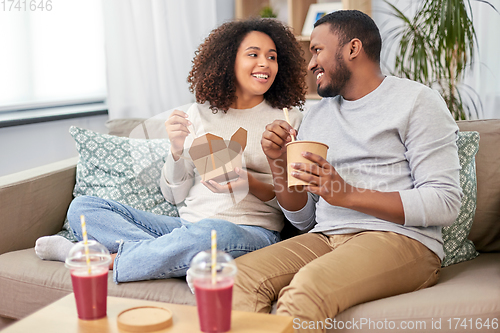 Image of happy couple with takeaway food and drinks at home