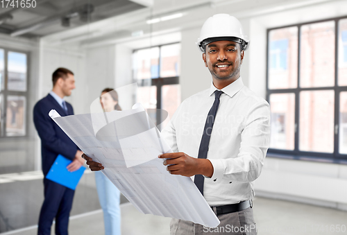 Image of indian male architect with blueprint at office