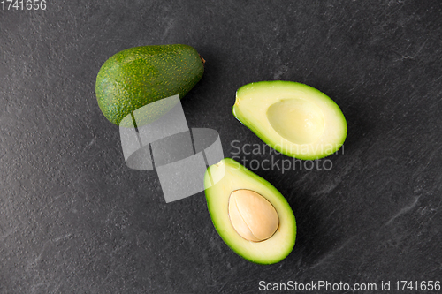 Image of close up of ripe avocado on slate stone background