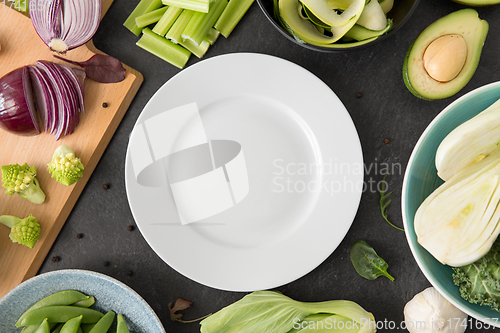 Image of different green vegetables and white empty plate