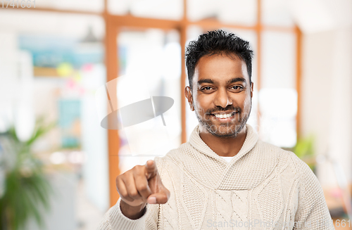 Image of smiling indian man pointing finger to camera