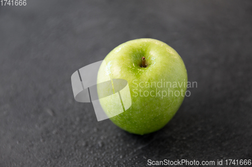 Image of ripe green apple on slate stone background