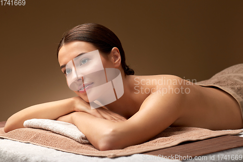 Image of young woman lying at spa salon or massage parlor