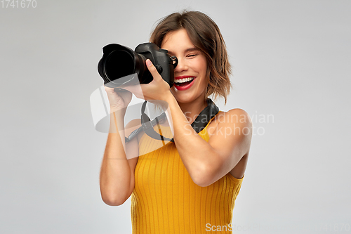 Image of happy woman photographer with digital camera