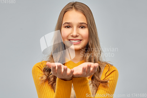 Image of teenage girl holding something on empty hands