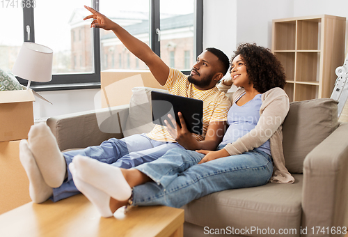 Image of happy couple with tablet pc computer at new home