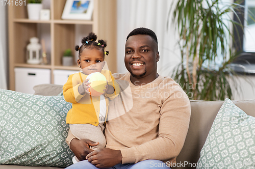 Image of happy african american father with baby at home