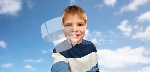 Image of happy little boy in striped pullover taking selfie