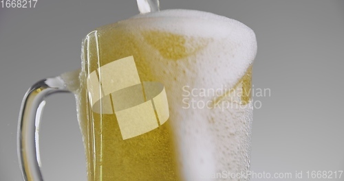 Image of Beer overflowing from large mug 120fps slow motion footage