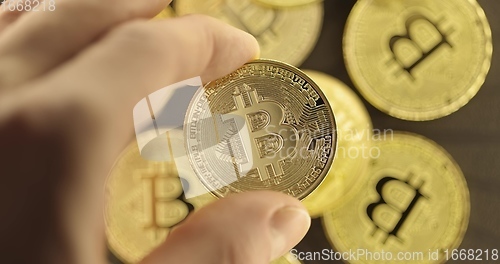 Image of Inspecting Physical bitcoin held in hands closeup