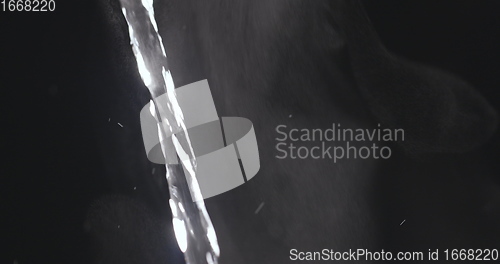 Image of Pouring hot water against dark background