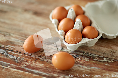 Image of close up of eggs in cardboard box on wooden table