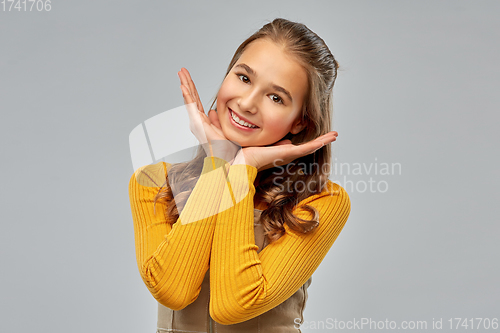 Image of smiling teenage girl over grey background