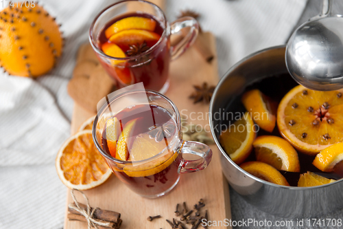 Image of pot with hot mulled wine, orange slices and spices