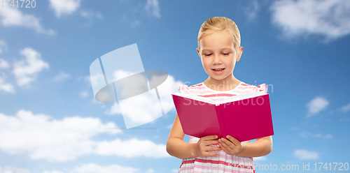 Image of little girl reading book over sky background