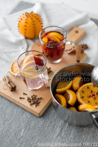 Image of pot with hot mulled wine, orange slices and spices