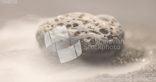 Image of Smoke whirling around small meteorite stone