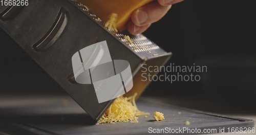 Image of Grating cheddar cheese in natural light 120 fps slow motion footage