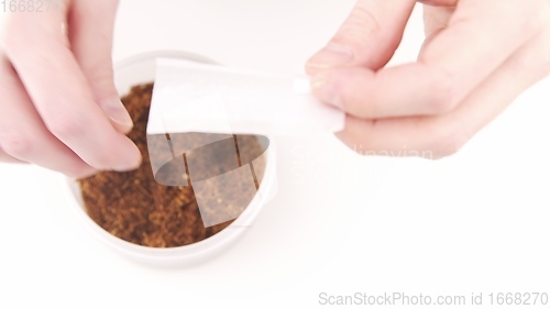 Image of Man Hands Rolling a Cigarette of Tobacco