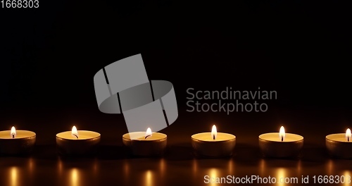 Image of Candles glowing against dark background