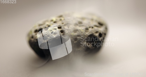 Image of Smoke whirling around small meteorite stone