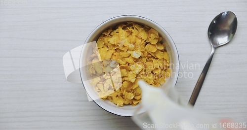 Image of Pouring milk into bowl of cereals