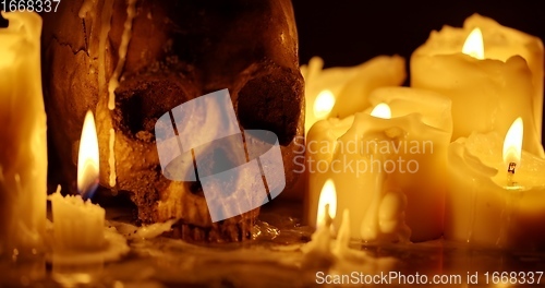 Image of Candles and human skull in darkness closeup footage