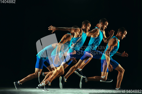 Image of Professional male runner training isolated on black studio background in mixed light