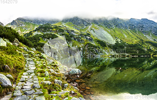 Image of Tourist hiking trail along the picturesque mountain lake