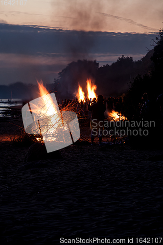 Image of Unrecognisable people celebrating summer solstice with large bonfires on beach