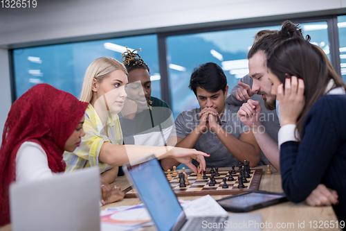 Image of multiethnic group of business people playing chess