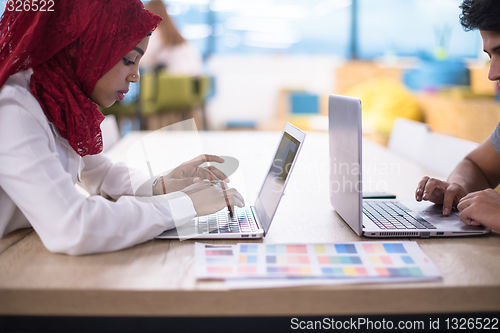 Image of black muslim business woman ,working on laptop computer