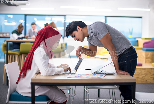 Image of black muslim business woman having a meeting with her indian mal