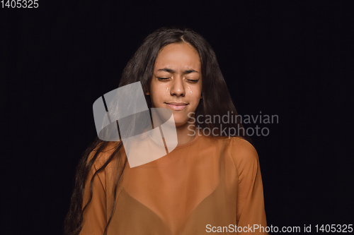 Image of Close up portrait of young woman isolated on black studio background