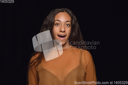 Image of Close up portrait of young woman isolated on black studio background