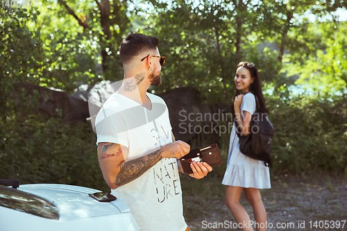 Image of Young couple preparing for vacation in sunny day