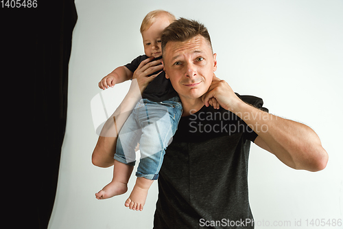 Image of Happy father holding adorable little son and smiling