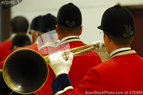 Image of back view of musicians playing on hunting horns