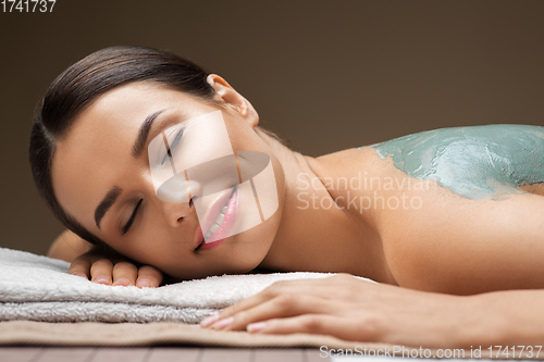 Image of woman with blue clay mask in spa